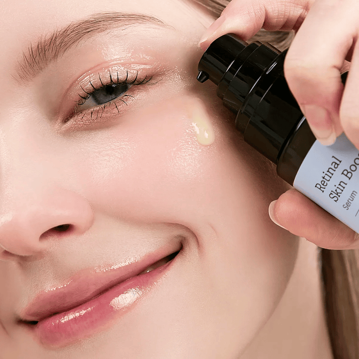 Person applicerar Meditherapy Retinal Skin Booster Serum nära ögat. Serumet har en lätt, gul ton och ger huden lyster och fasthet.