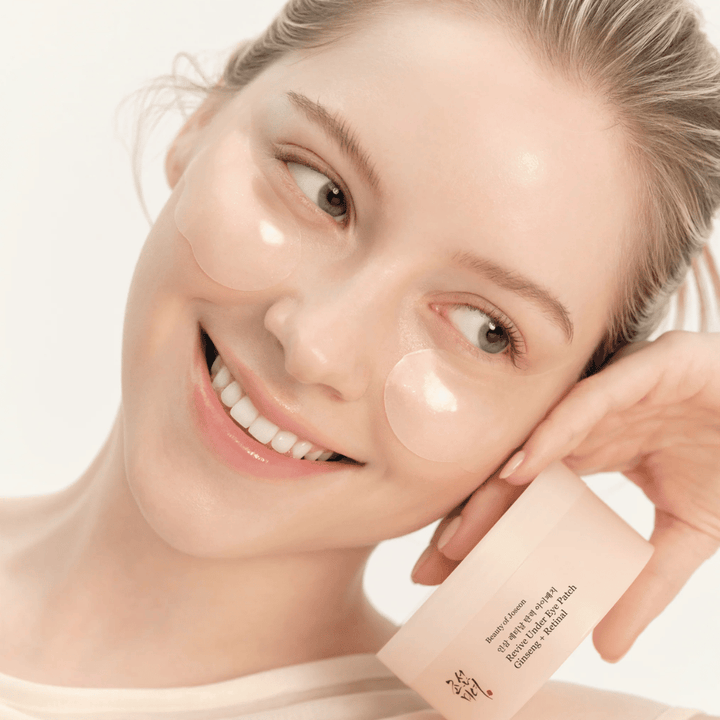 Modell mit Beauty of Joseon Under Eye Patches und Produkt in der Hand, Augenpatches mit Ginseng und Retinal für ein wacheres und glatteres Augenbereich.