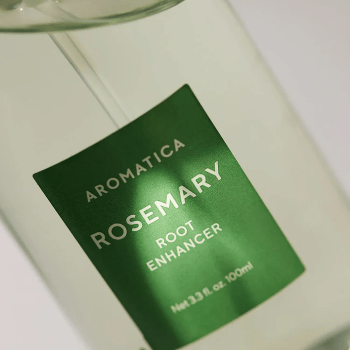 Detailaufnahme des Etiketts auf AROMATICA Rosemary Root Enhancer. Das grüne Etikett und die transparente Flasche unterstreichen das saubere und minimalistische Erscheinungsbild des Produkts.