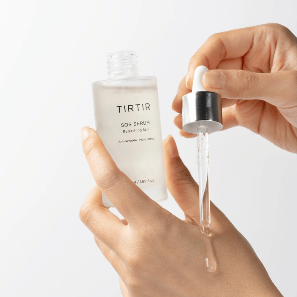 Hände, die TIRTIR SOS Serum von einer Pipette tropfen, vorgesehen für Hautpflege.