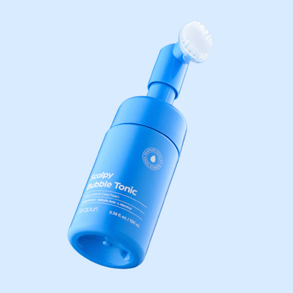 Stilvolles Produktbild von Seapuri Scalpy Bubble Tonic vor hellblauem Hintergrund, der das moderne Design und den einzigartigen Bürstenkopf für die Kopfhautpflege hervorhebt.