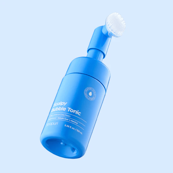 Stilvolles Produktbild von Seapuri Scalpy Bubble Tonic vor hellblauem Hintergrund, der das moderne Design und den einzigartigen Bürstenkopf für die Kopfhautpflege hervorhebt.