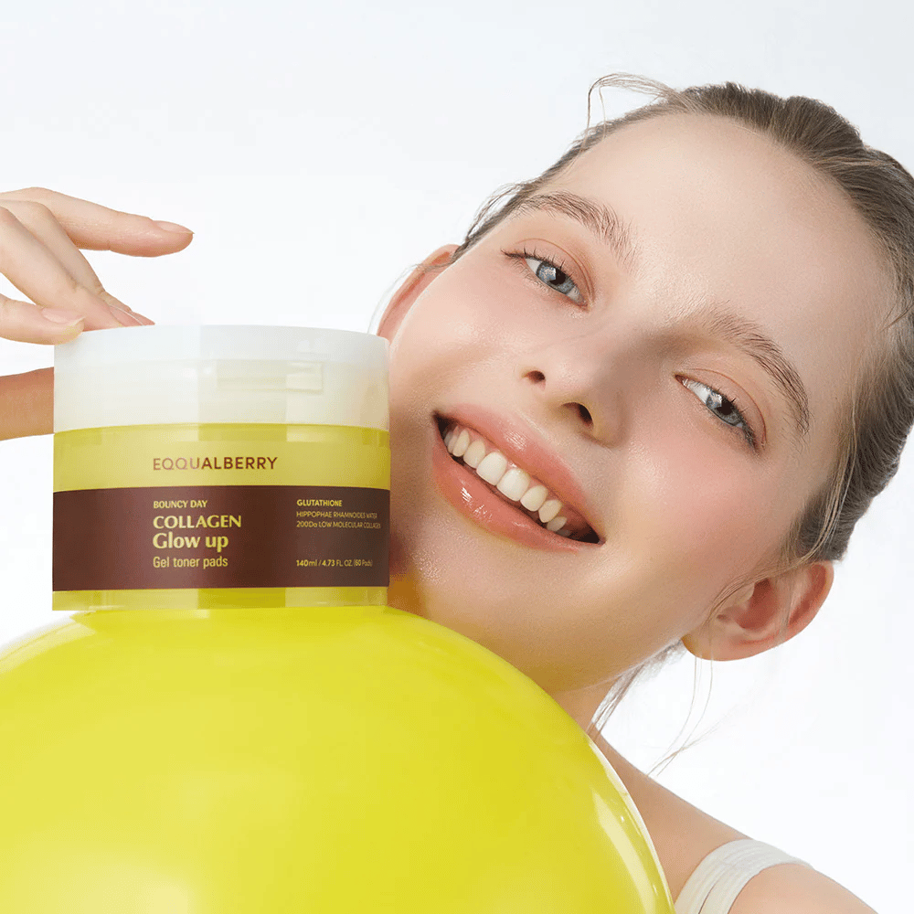 Lächelndes Modell hält Bouncy Day Collagen Glow up Gel Toner Pads, das hilft, einen jugendlichen Glanz und Festigkeit mit niedrigmolekularem Kollagen und Glutathion zu verleihen.