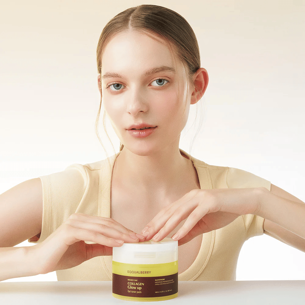 Modell hält Bouncy Day Collagen Glow up Gel Toner Pads, das mit niedrigmolekularem Kollagen und Glutathion Feuchtigkeit spendet und einen schönen Glanz verleiht.