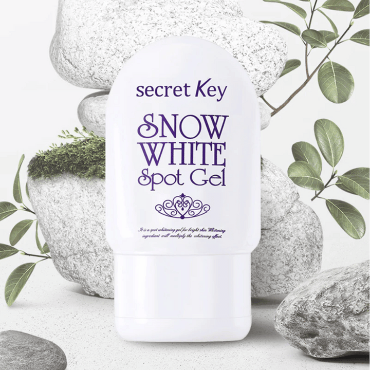 Secret Key Snow White Spot Gel fotograferad mot stenar och gröna blad.