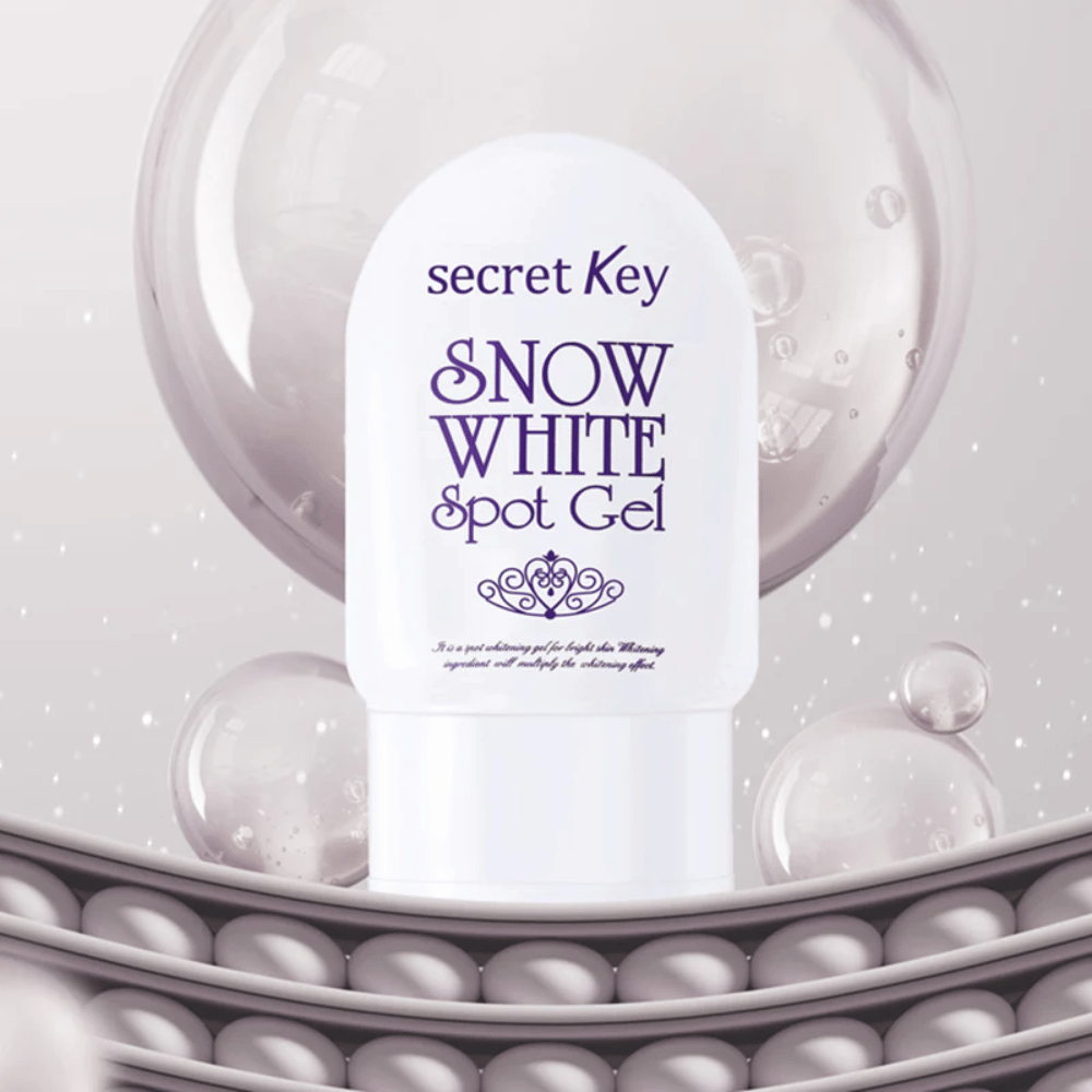 Secret Key Snow White Spot Gel i vit förpackning mot bakgrund med bubblor och pärlliknande detaljer.
