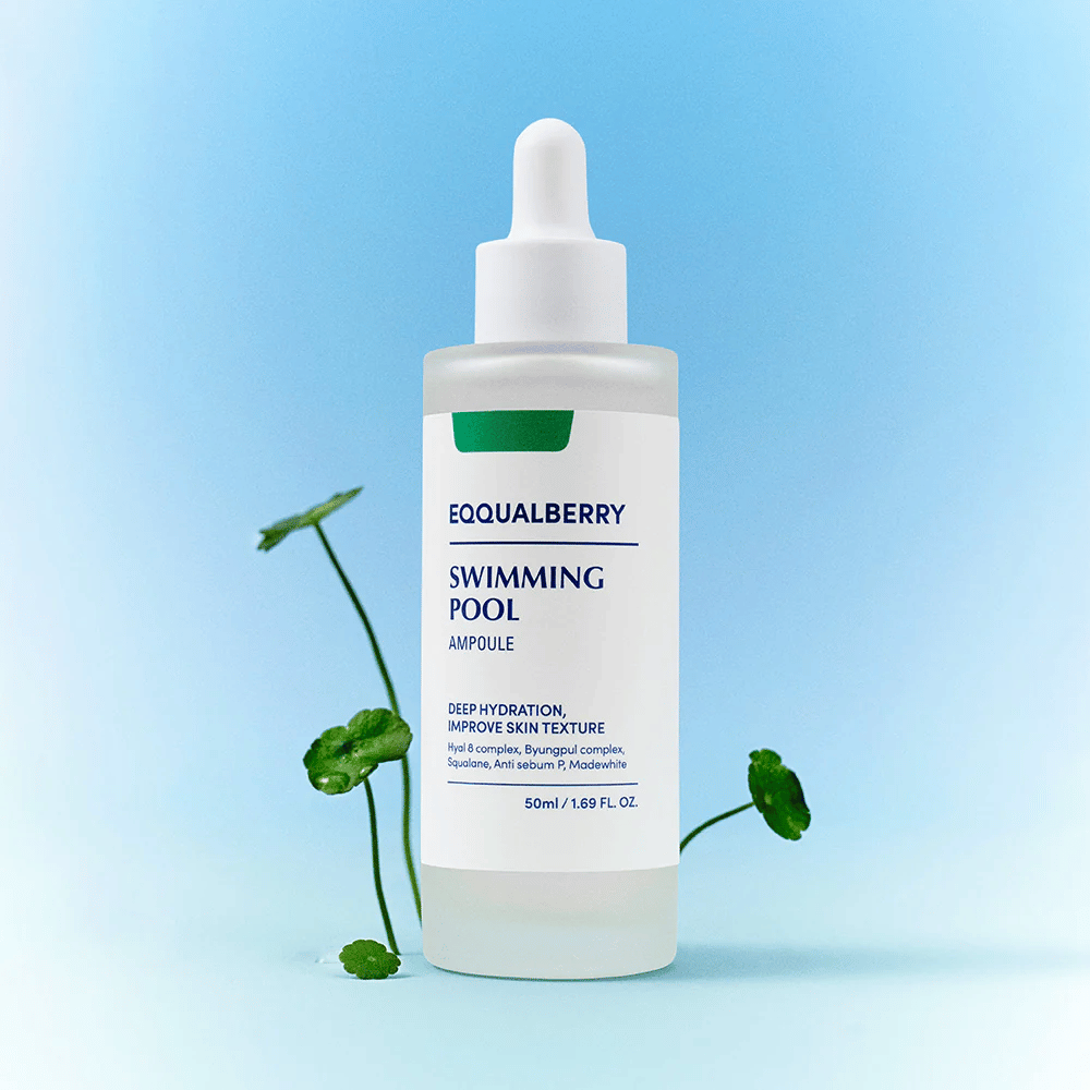 Flasche mit Eqqualberry Swimming Pool Ampoule, ein Hautpflegeprodukt für tiefe Feuchtigkeit und verbesserte Hautstruktur, platziert auf einem hellblauen Hintergrund mit einigen grünen Pflanzen im Vordergrund.