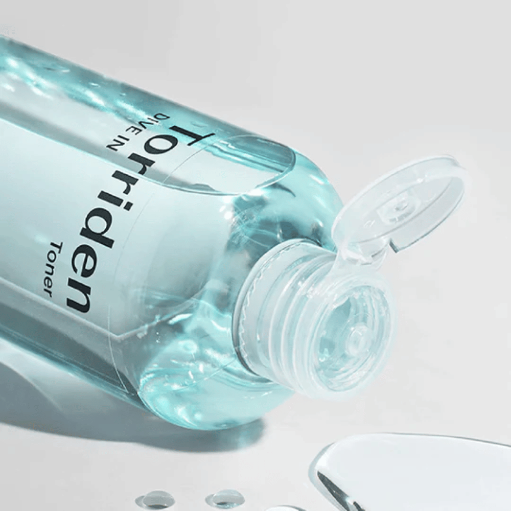 Eine Flasche DIVE-IN Low Molecule Hyaluronic Acid Toner 300ml neben einem Glas Wasser, fördert Torriden und Feuchtigkeit.