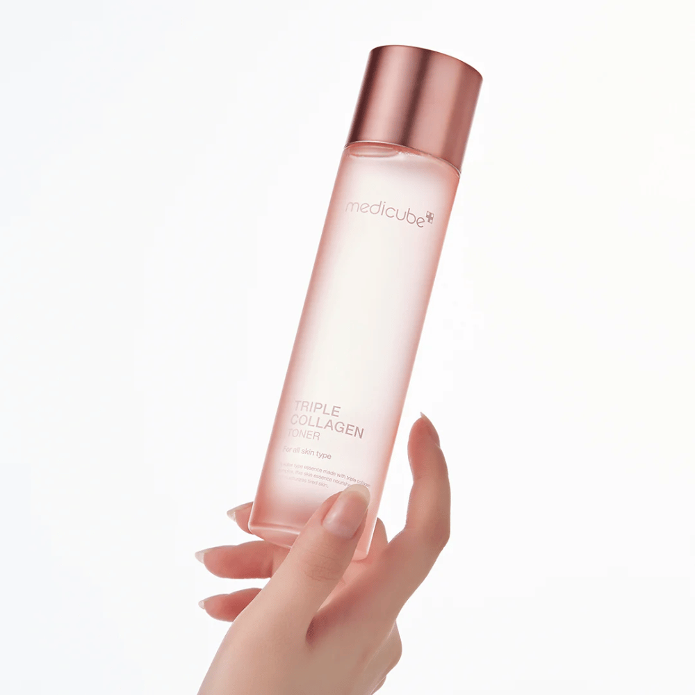 Hand hält eine rosa Flasche von Medicube Triple Collagen Toner 4.0, ein feuchtigkeitsspendendes und straffendes Tonikum für alle Hauttypen.