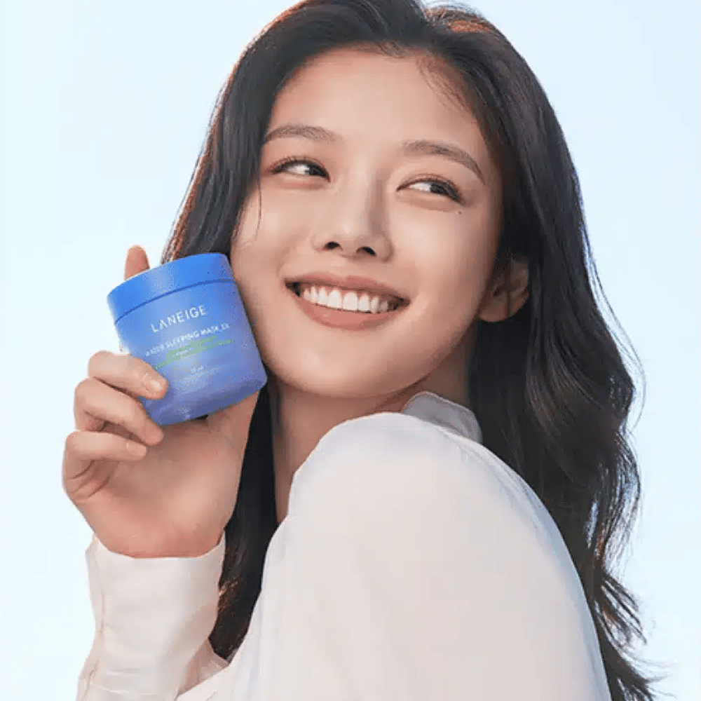 Lächelnde Frau hält eine blaue Dose von LANEIGE Water Sleeping Mask vor hellblauem Hintergrund.