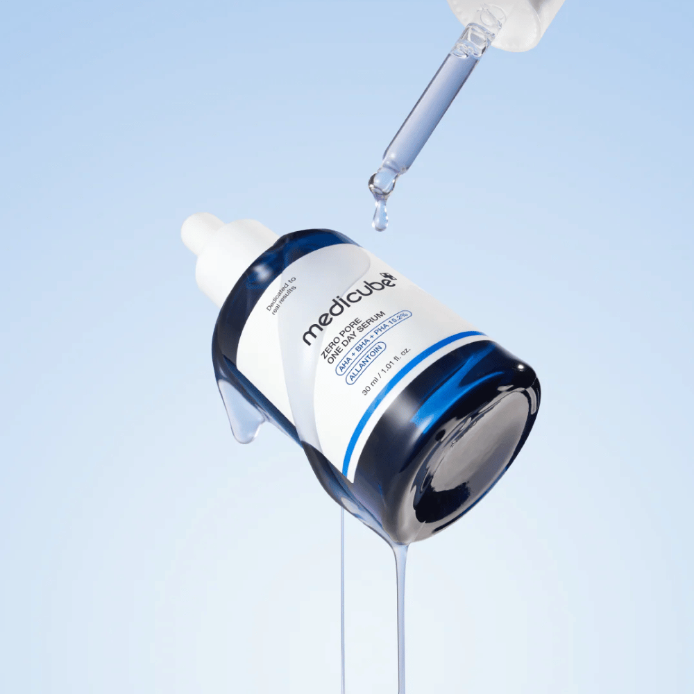 Flasche von Medicube Zero Pore One Day Serum mit Pipette und tropfendem Serum vor einem hellblauen Hintergrund.