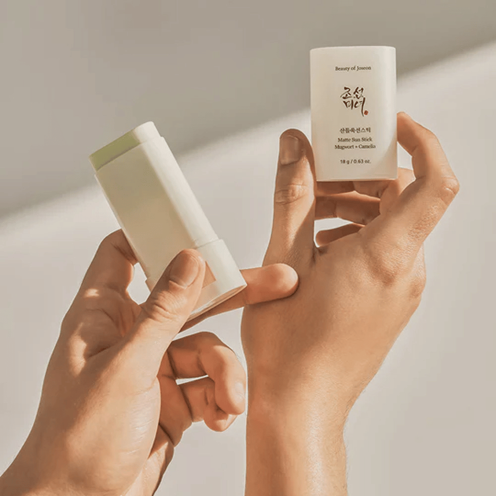 Zwei Hände, die einen Stick von Beauty of Joseon's Matte Sun Stick 18g SPF50 PA++++ halten.