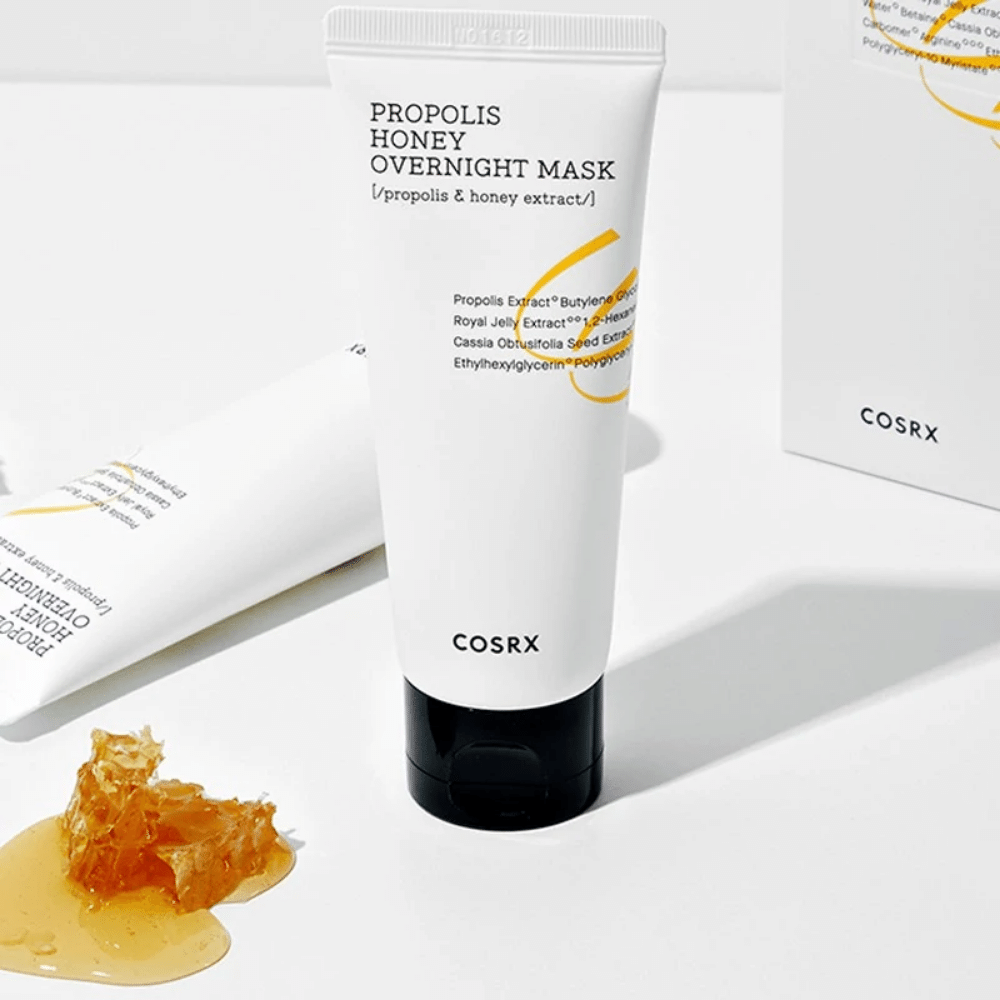 Eine Schachtel Full Fit Propolis Honey Overnight Mask 60ml von COSRX mit einer Flasche Honig daneben, mit Propolisextrakt.